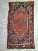 Hand knotted rug featuring center medallion and floral border. Measures 31-in x54 in.