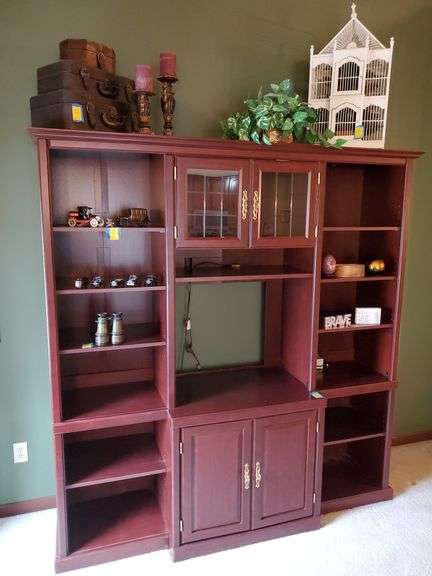 Sauder display unit / entertainment center features upper lighted shelving, solid brass hardware in a cherry finish. Measures 72 in W X 21 in D X 78 in H. DOES NOT INCLUDE ANY CONTENTS. Living room