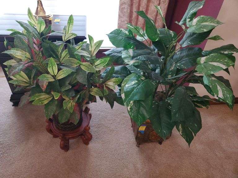 2 artificial plants in ornate planters, one with wood stand. Living room