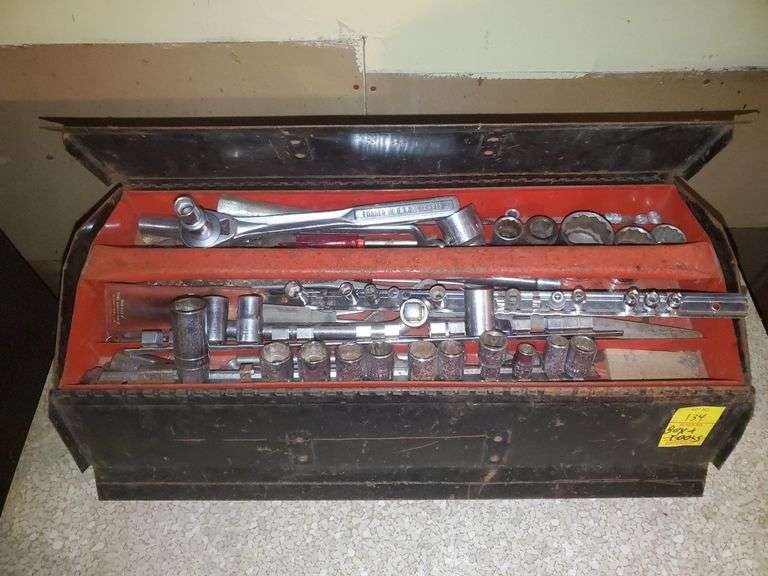 Sentry 21-in wide steel toolbox with removable top tray, half inch drive and 3/8 drive ratchets by Craftsman, miscellaneous sockets in 1/4, 3/8, 1/2 sockets by Craftsman and others, nut driver, ratchet extensions, miscellaneous wrenches by Craftsman and others. Basement Workshop.