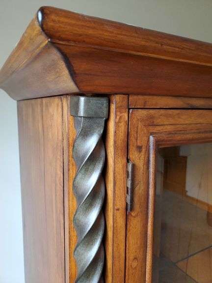Beautiful solid wood entertainment center featuring beveled edged glass on doors, twisted metal accents in antique bronze finish, glass shelves with overhead lights, and plenty of storage, measures 108 in wide 24 in D X 74 in h. Breaks down into approximately five pieces. Family room.