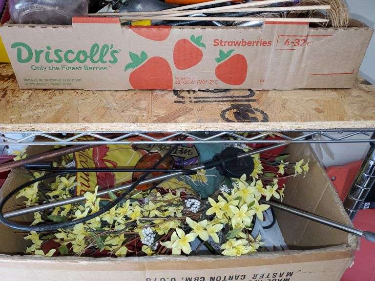 (2) shelf lot of gardening items including Miracle-Gro fertilizers, size 9 Garden Crocs, work gloves, planting pots, spring wreath, outdoor welcome flag. Garage