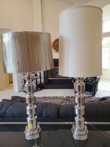 (2) modern style Chrome finish table lamps with pleated metallic look shade standing 38 in tall and white fabric shade standing 45 in tall. Living room.