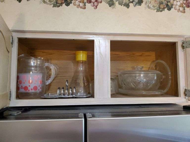 Vintage glass pitcher, cheese tray and serving bowls. Above refrigerator