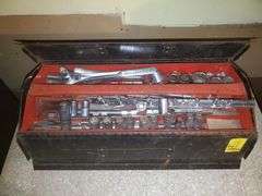Sentry 21-in wide steel toolbox with removable top tray, half inch drive and 3/8 drive ratchets by Craftsman, miscellaneous sockets in 1/4, 3/8, 1/2 sockets by Craftsman and others, nut driver, ratchet extensions, miscellaneous wrenches by Craftsman and others. Basement Workshop.