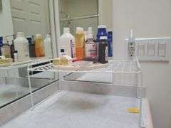 Bath Towels, Hand Towels, Wire Organizer Stand with contents, Ceramic Wall art, and Crestor Wall Clock