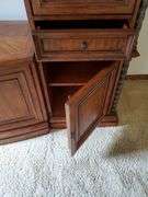 Beautiful solid wood entertainment center featuring beveled edged glass on doors, twisted metal accents in antique bronze finish, glass shelves with overhead lights, and plenty of storage, measures 108 in wide 24 in D X 74 in h. Breaks down into approximately five pieces. Family room.