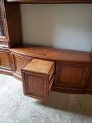 Beautiful solid wood entertainment center featuring beveled edged glass on doors, twisted metal accents in antique bronze finish, glass shelves with overhead lights, and plenty of storage, measures 108 in wide 24 in D X 74 in h. Breaks down into approximately five pieces. Family room.