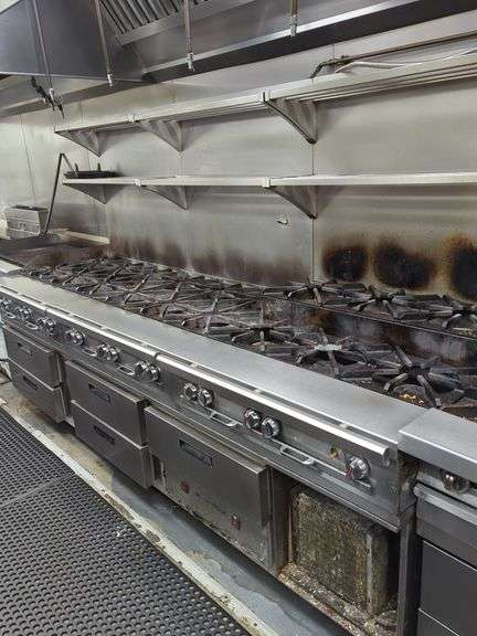 Gang of (3) 6 burner 36x32 tabletop gas stoves on stand. One has steppe back burner. Includes under counter cooler drawers that are currently not working. Stoves are excellent. Includes 36" back shelves.