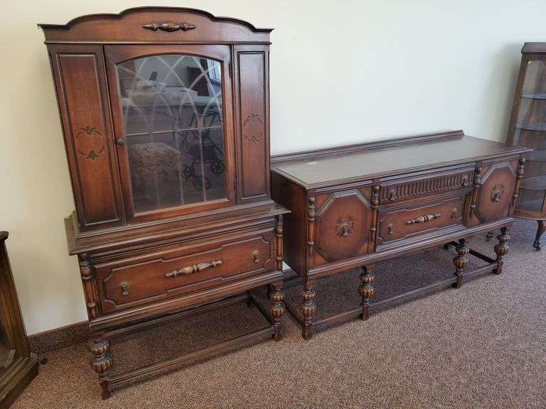 Vintage dining room set including table with built-in leaves (measuring 62 in l X 38 in w x 30 in H with leaves in and 94 in l with leaves extended), (1) Captain's chair with red upholstered seats, (5) dining chairs with red upholstered seats, solid wood china cabinet and side board. China cabinet features upper shelf with plate rail, lower storage drawer and measures 40 in WX 17 in D X 67 in H. Sideboard features raised wood side doors, ample storage and measures W X 20 in D X 37 in H. All pie