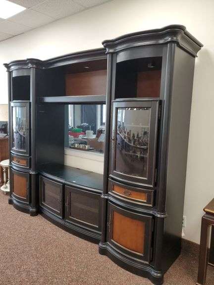 Audio/video/display cabinet with finish, stained wood accent panels, beveled edge curved glass door fronts, brass hardware and lighted upper display shelves measures 96 in WX 24 in D X 83 in H.