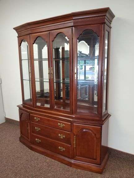 Beautiful Bernhardt lighted China cabinet features bevel edge front door glass, mirrored back, solid brass hardware, Eastlake style accents on top. Cabinet measures 64 in W x 17 in D X 81 in H