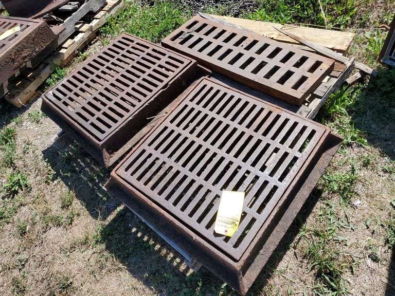 Pair of cast iron flange and grate drain covers with flange measuring 28 in square and grates measuring 23 in square, heavy duty cast iron grate 12 in w x 36 in L X 2 in H. Tow motor available to load onto trailer