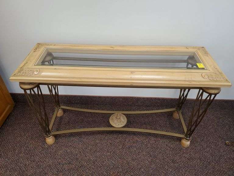 Ornate wood and bronze toned bent metal console table with beveled edged glass top measures 52 in W X 18 in D X 30 in H.