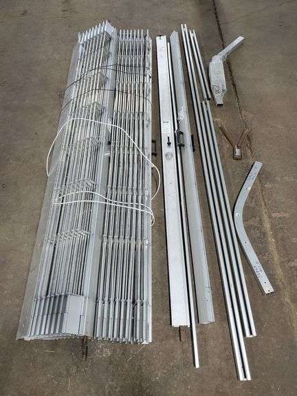 Metro folding locking gate  in (3) sections each measuring 68" wide X 95" tall with upper track rails. Total of 17 ft of width. Appears to be complete system. Would need a locksmith to make new keys as the original keys are missing. Includes wood box storage case. See photos. Tow motor available for loading onto trailer.