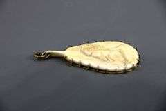 10 KT Gold framing of a carved tribal figure on bone Pendant.