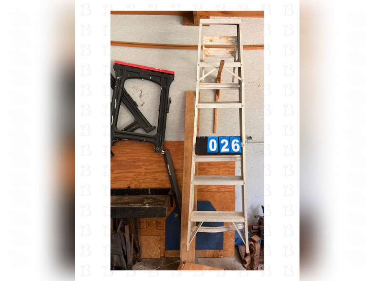 A pair of sawhorses, a 8ft ladder, and construction light with stand.