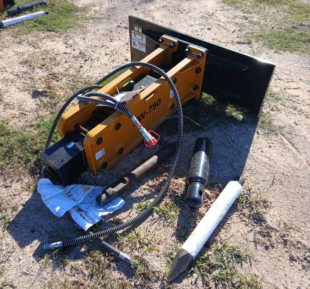 Unused skid steer auger drive with auger bits selling at auction in Alexandria, Louisiana