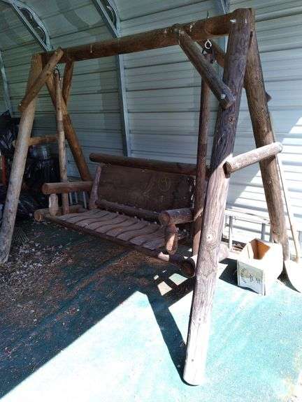 Rustic log bench swing in carport