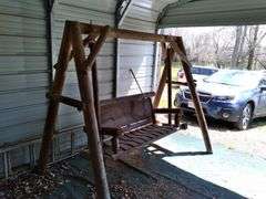 Rustic log bench swing in carport