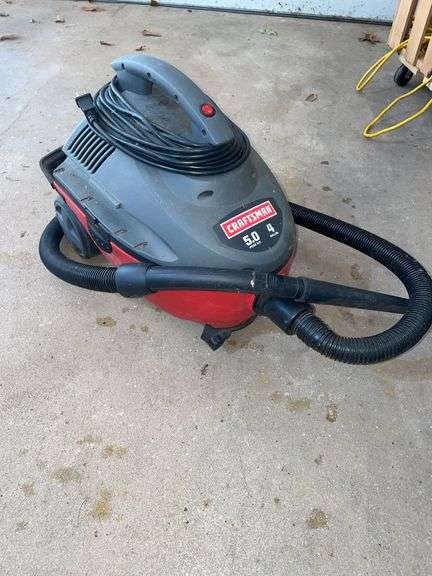 Garage. Craftsman 4 gallon shop vac. Powered on.