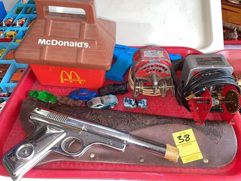 Garage. Lot of vintage toys featuring Daisy number 118 target tier. Vintage McDonald’s happy meal case. Erector a 47 electric engine. Placo toy vintage dart gun with dart. Some vintage cast toy vehicles.