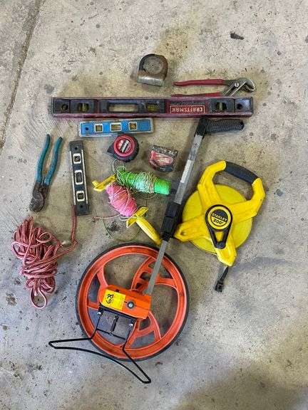 Lot includes measuring wheel and tape, string markers, and miscellaneous.