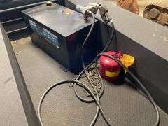 Better Build heavy duty hundred gallon black steel rectangle transfer tank. In bed of truck. Includes red fuel tank and come along chain.