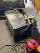 Better Build heavy duty hundred gallon black steel rectangle transfer tank. In bed of truck. Includes red fuel tank and come along chain.
