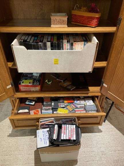 Basement. Contents of cabinet, which include VHS tapes with some well-known movies. Cassettes and CDs. Large assortment.