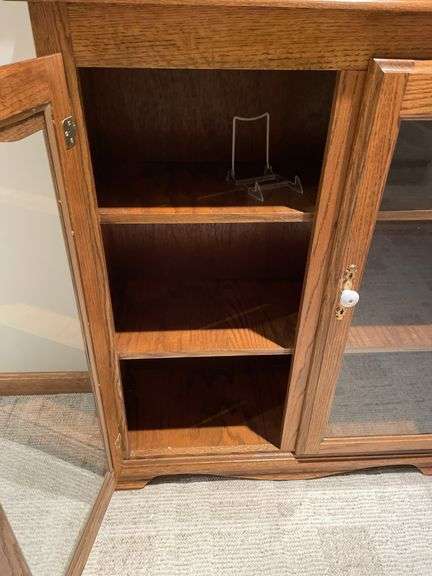 Basement. Cabinet with glass front shelves, approximately 58 inches tall and 37 inches wide.