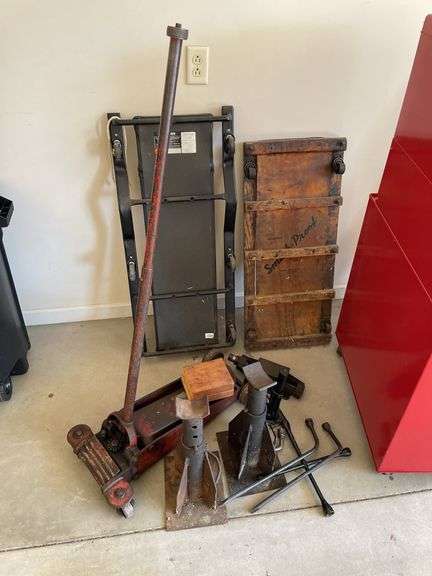 Automotive lot includes floor jacks, creepers, tire irons.