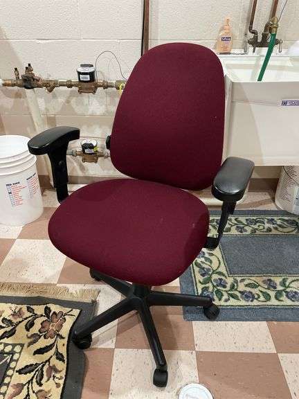 Basement. Maroon upholstered, rolling computer office chair.