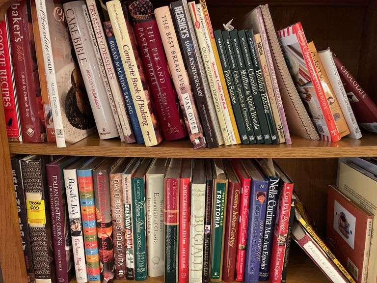 Contents of bookcase includes mainly cookbooks.