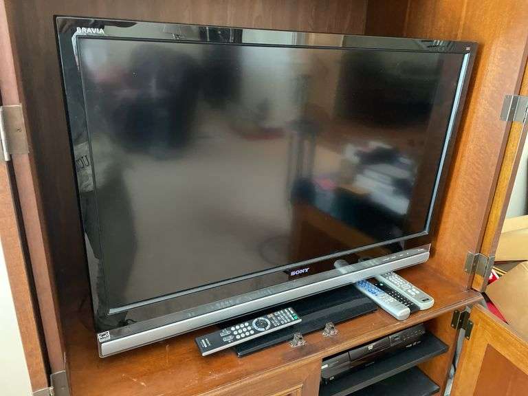 Living room. 40 inch Sony Bravia KDL – 40 XBR6 TV with remote powers on and is working includes Philips Magnavox DVD player.