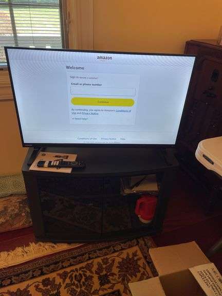 Den. 32 inch Toshiba fire TV with remote. And glass fronted entertainment stand. Powers on.