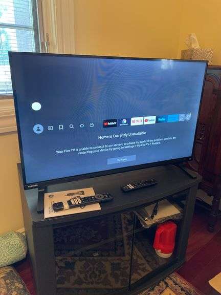 Den. 32 inch Toshiba fire TV with remote. And glass fronted entertainment stand. Powers on.