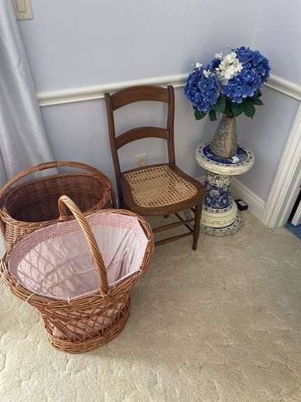 Master bedroom. Vintage ratan chair with large laundry baskets plant stand with faux plant.