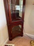 Living room. Corner curio cabinet with standing lamp. Curio is 78 inches tall by approximately 27 inches wide.