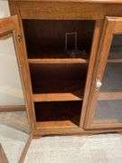 Basement. Cabinet with glass front shelves, approximately 58 inches tall and 37 inches wide.