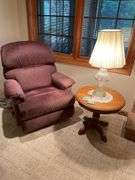 Basement. Recliner with round side table and ornate lamp.