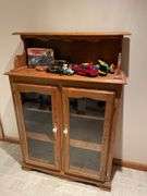 Basement. Cabinet with glass front shelves, approximately 58 inches tall and 37 inches wide.