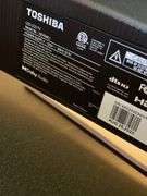 Den. 32 inch Toshiba fire TV with remote. And glass fronted entertainment stand. Powers on.