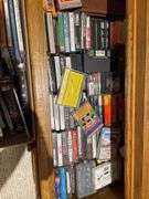 Basement. Contents of cabinet, which include VHS tapes with some well-known movies. Cassettes and CDs. Large assortment.