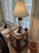 Living room. Two matching lamps with two side tables (one is a glass curio side table) and TV trays on stand. One TV tray is missing. Nice lot of furniture.