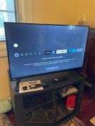 Den. 32 inch Toshiba fire TV with remote. And glass fronted entertainment stand. Powers on.