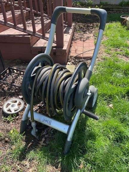 Backyard. AMES hose roller with garden hose and attachment.