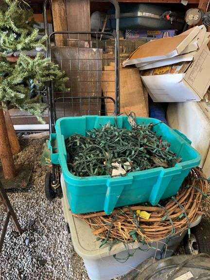 Two tubs of Christmas lights, primitive Christmas tree, and grocery cart.