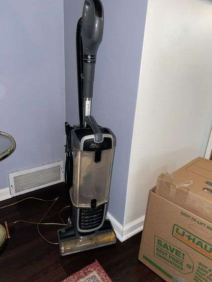 Den. Shark navigator vacuum. Power is on. This unit needs cleaned up.