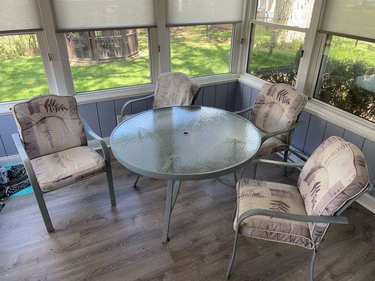 Florida room. Glass top round table 50 inches wide with four matching chairs that come with cushions. This piece has been kept inside and is in good condition.